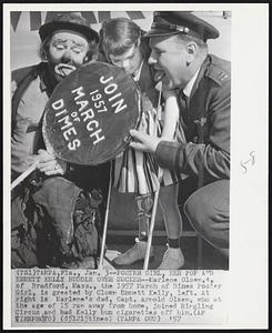 Poster Girl, Her Pop and Emmett Kelly Huddle Over Sucker -- Marlene Olsen, 4, of Bradford, Mass., the 1957 March of Dimes Poster Girl, is greeted by Clown Emmett Kelly, left. At right is Marlene's dad, Capt. Arnold Olsen, who at the age of 15 ran away from home, joined Ringling Circus and had Kelly bum cigarettes off him.
