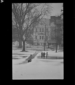Children walking in snow in front of Woodbridge School