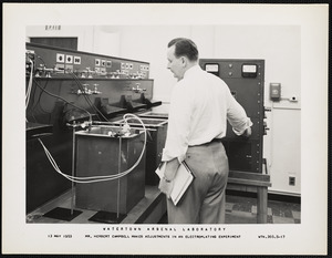 Mr. Herbert Campbell makes adjustments in an electroplating experiment