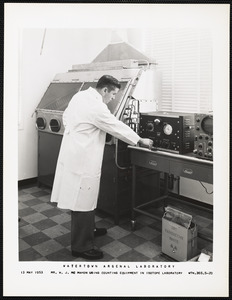 Mr. W.J. McMahon using counting equipment in isotope laboratory