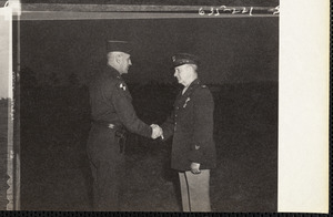 Military personnel in field, shaking hands