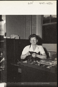 Men operating machinery, woman making eyeglasses