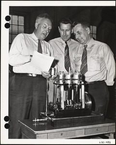 Three men reviewing MacIntosh-Seymour Marine Steam Engine