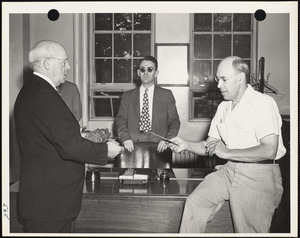 Three men, one holding award