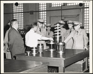 Officers and men observing machine parts