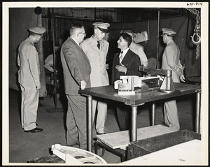 Officers and men observing machine parts