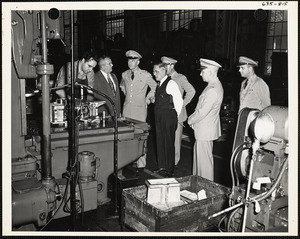 Officers and men observing machinery