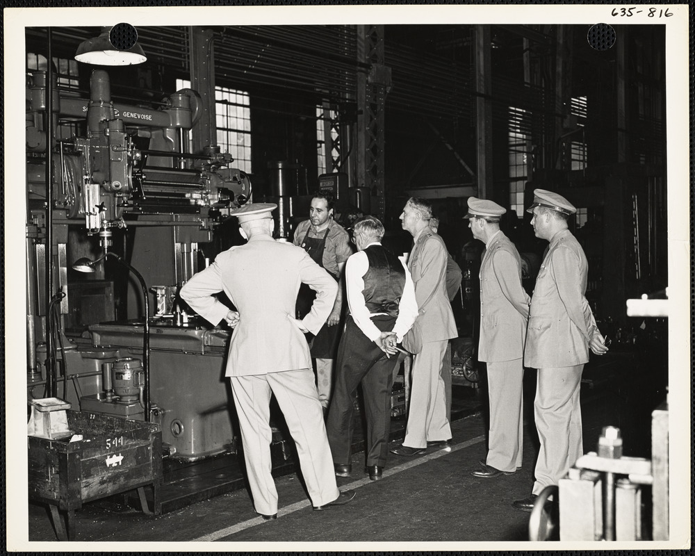 Officers and men observing machinery