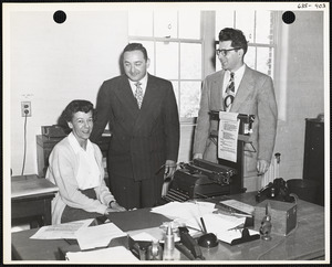 Men and woman with typewriter at desk