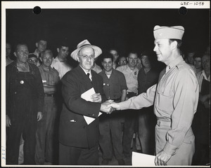 Soldier and worker shaking hands