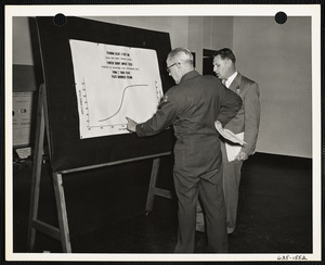 Two men talking with chart