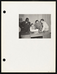 Four men looking at document
