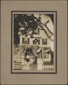 Family portrait in front of 3 story clapboard house