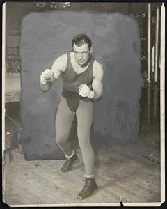 Jack Sharkey in Training for Bout With Maloney. Jack Sharkey, young Boston heavyweight who will meet Jimmy Maloney, also of Boston, in a fifteen round bout at the Yankee Stadium, May 19th, to decide a possible opponent for Gene Tunney, is now training for the fight at Stillman's Gym. He is shown here in a characteristic fighting pose.
