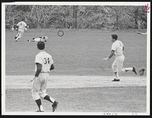 Decisive Run - Paul Costello (2) of Catholic Memorial heads toward third base as outfielders Jim Flood, on ground, and Charles Gianturco (6) of St. John's Prep run down double hit by Kevin Maus in fourth inning of game at Danvers. An unhappy Jerry Morris (34), losing pitcher, looks on.