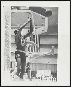 Kicking the Ball Around--Philadelphia 76ers Wilt (The Stilt) Chamberlain (13), 7-foot-1 incher comes up empty handed as ball gets away apparently kicked by Detroit Pistons Tom Van Arsdale (5) in this first half action of game at Detroit tonight. The rebounding ball was not kicked but eluded both players.