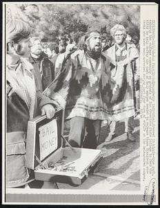 Sympathetic individual, dressed in hippie-type garb, exhorts the college community on grounds of San Francisco State College to feed the kitty to help defray the cost of bail monies needed to release those dissident students who have been arrested during last four days of strife on the beleaguered campus.