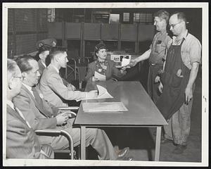 Lynn Employes of the General Electric Company coting to determine which union will represent them. Mrs. Judith White of Brockton hands ballots to Alexander Zalenski and Gabriel Gouvera. Jack Lynch, at the table (left) is check-off man.