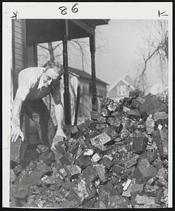 Miner Gets Ready For Winter -- John F. Greeney, idle soft coal miner, begins storing 100 bushels of coal in cellar of his home in Blaine, O.
