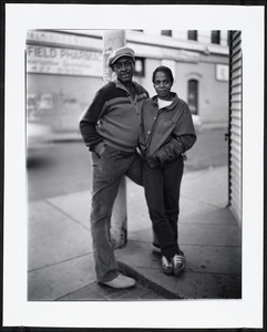 Man and woman stand near a street corner