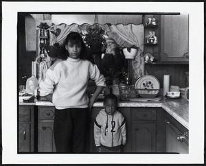 Boy and young woman stand in kitchen