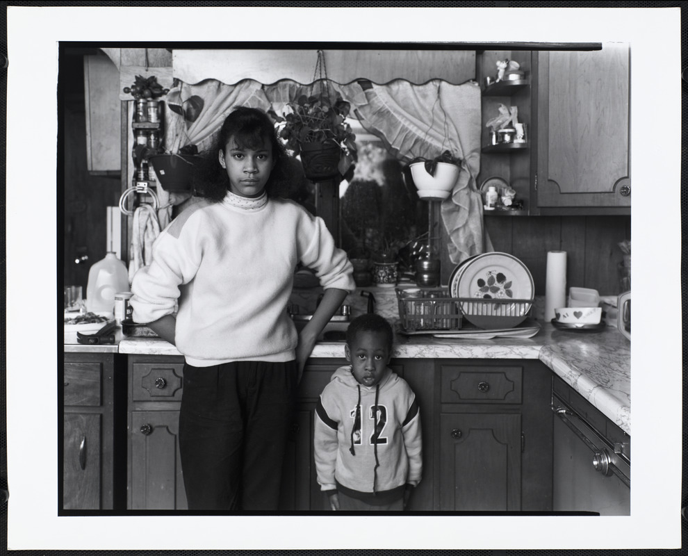 Boy and young woman stand in kitchen