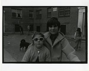 Portrait of a boy and a girl in sunglasses in a courtyard