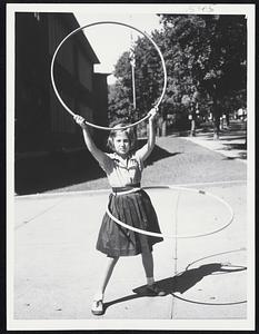 Hoop Champ-Eleven-year-old Judy Nydon of Brookline re-enacts some of the 20,781 spins with hula hoop which mad her local-perhaps U.S.-champion.