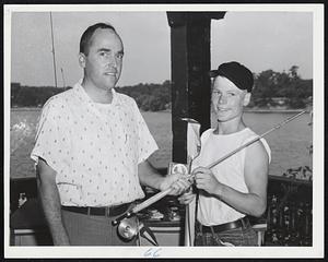Bob Antone of 202 Highland St., Roxbury, accepts his first place prize from Hal Lyman, publisher of Salt Water Sportsman. Bob hooked a 10-ounce yellow perch at the Boston Traveler-Boston Park Department Fishing Rodeo at Jamaica Pond.