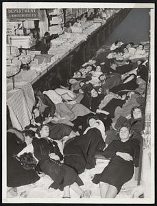 Girl "sit-downers" are shown sleeping in New York unit of the Woolworth stores as union leaders defy "Barbara Hutton and all her millions."