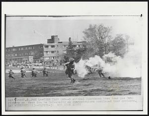 Toss Tear Gas-- National Guardsmen toss tear gas into rioters on Kent State University as demonstrators continued their protests.