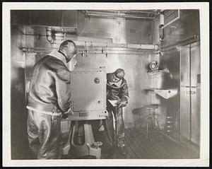 All-Weather Laboratory. Brooklyn, N.Y.--In this stainless steel room two warmly dressed men test an anti-aircraft director. The room is the Sperry Gyroscope Company's all-weather laboratory which the company built a year ago so that could test equipment under weather conditi from severest cold to greatest heat. The room is never made colder than 50 degrees below zero or hotter than 150 degrees, stainless steel was used in its constructi corrosion-proof, and resistant to damage ultraviolet rays, used occasionaly to simulate torrid sunlight. The test shown above is being conducted in Arctic weather so the men wear helmets and heavy flying suits.