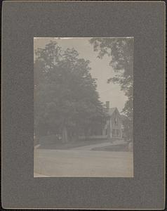 Colonial-style house with large tree