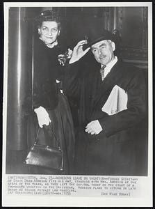 Former Secretary of State Dean Acheson tips his hat, standing with Mrs. Acheson at the steps of the train, as they left the capitol today on the start of a two-month vacation in the Caribbean. Acheson plans to return in late March to resume private law practice.