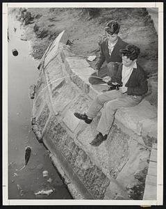 Fishin’s Fine-Jerry McLaughlin, 13, right, reels in a four-pound carp from Muddy River on the Fenway as Edward Doucette, 13, looks on enviously, wishing he too had brought along a fishing rod.