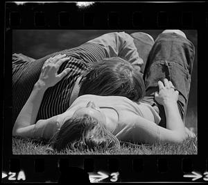 Couple relax in sun on Charles River embankment, Boston