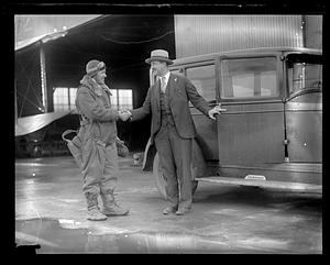 Unidentified aviator shaking hands with another man