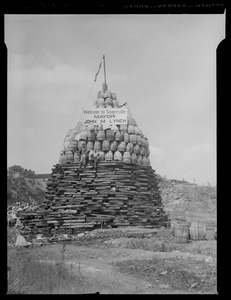 Structure made of logs and barrels with sign reading "Welcome to Somerville, Mayor John. M. Lynch"