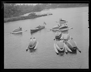 MDC police boat cuts through flock of paddle boats on Charles River at Norumbega Park