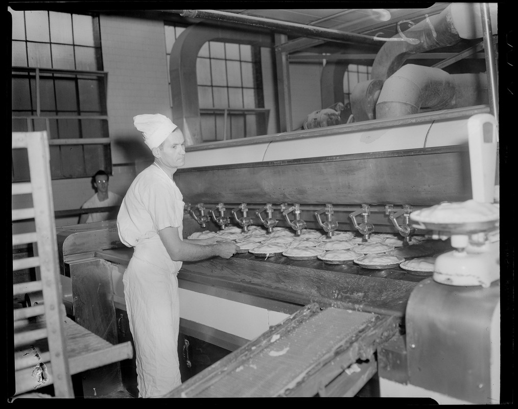 Charlie Sizilis placing pies in the oven, Table Talk factory in Worcester