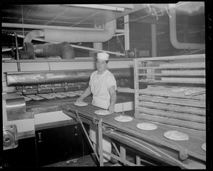 Andy Koskinas guiding pies onto conveyer belt to furnace, Table Talk factory, Worcester