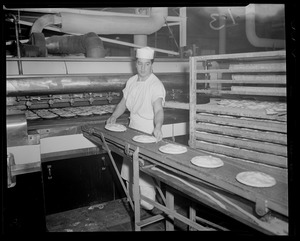 Andy Koskinas guiding pies onto conveyer belt to furnace, Table Talk factory, Worcester