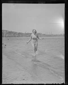 Wading woman finds the water at the beach a little cold
