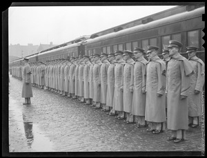 Men in uniform at attention next to train