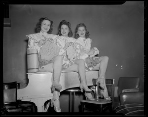 Show girls knitting on piano