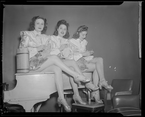 Show girls knitting on piano