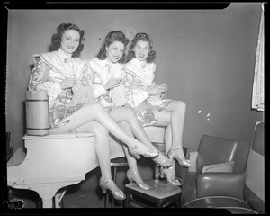 Show girls knitting on piano