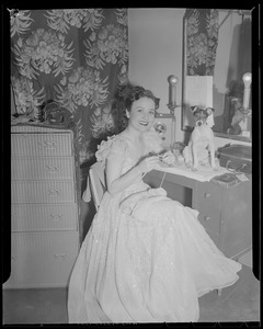 Show girl knitting in dressing room with her dog