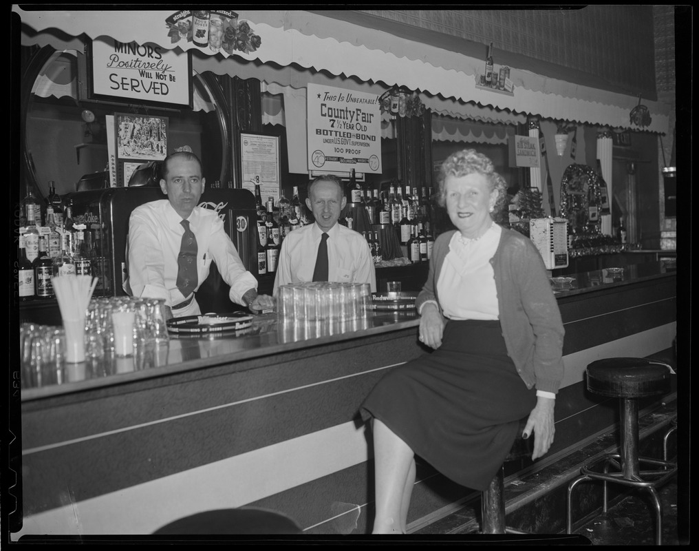 Woman at bar with two bartenders