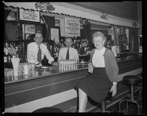 Woman at bar with two bartenders